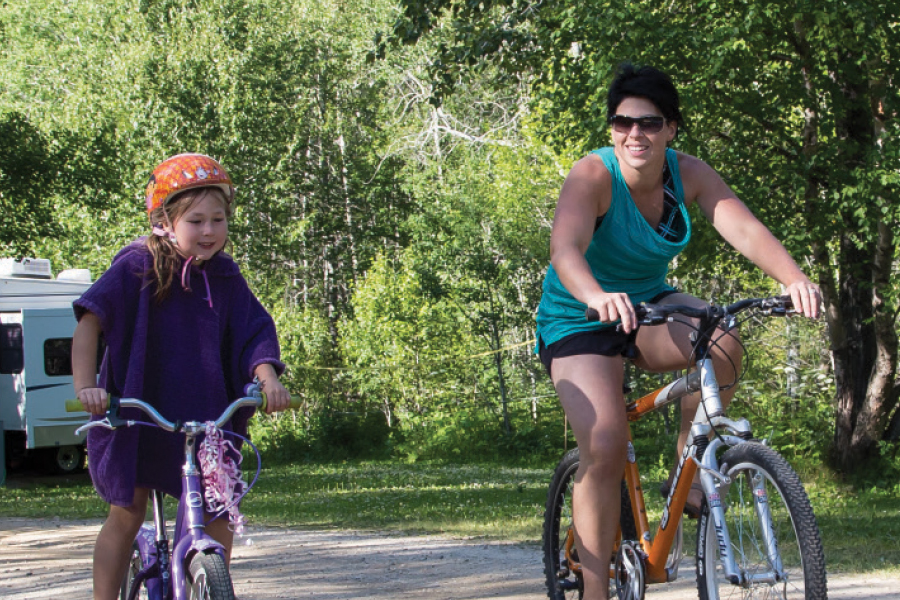 Mother and daughter having fun while cycling in the Parkland